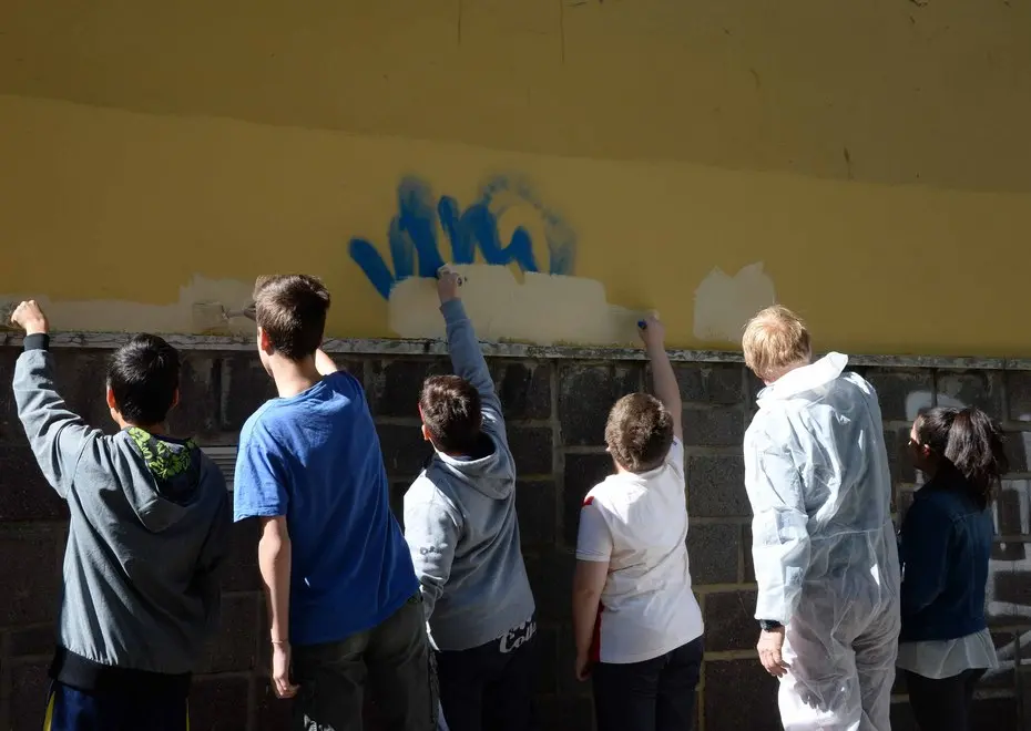 Studenti delle Bresadola puliscono dalle scritte i muri della scuola