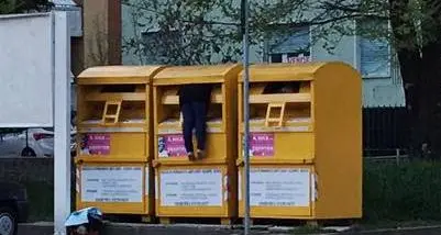 Si infilano nei cassonetti per recuperare abiti usati
