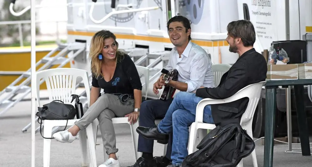 Riva, Scamarcio dopo il set concede autografi e imbraccia la chitarra
