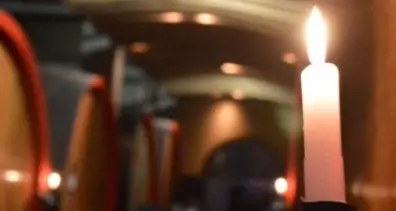 Candele in cantina con vini e prelibatezze