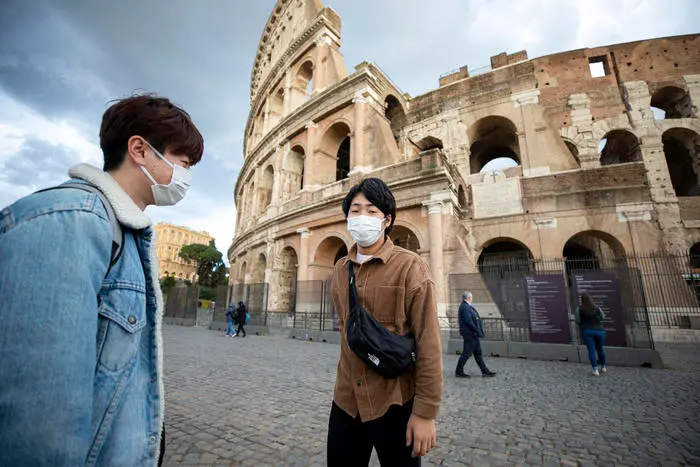 Turisti si proteggono dal virus con le mascherine al Colosseo a Roma 4 marzo 2020 ANSA/MASSIMO PERCOSSI