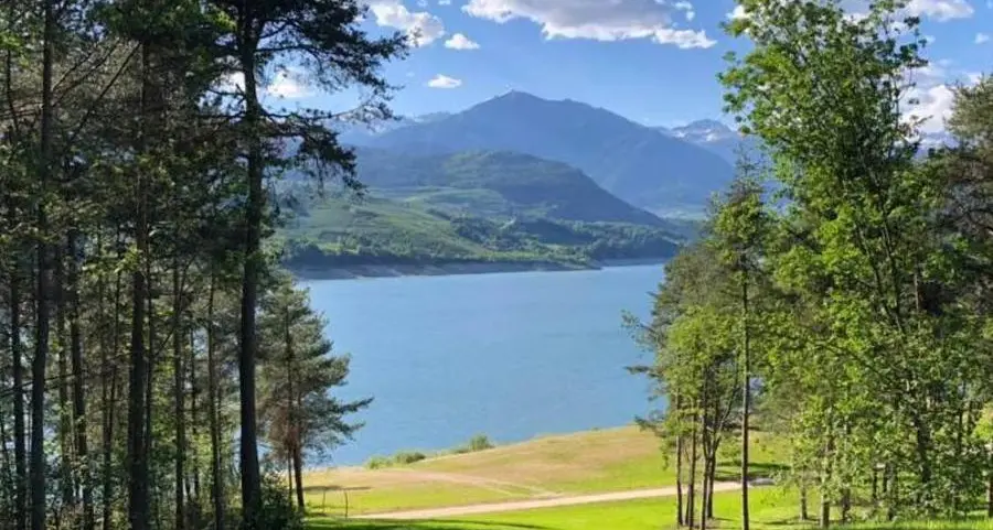 In riva al lago di Santa Giustina una spiaggia sempre verde