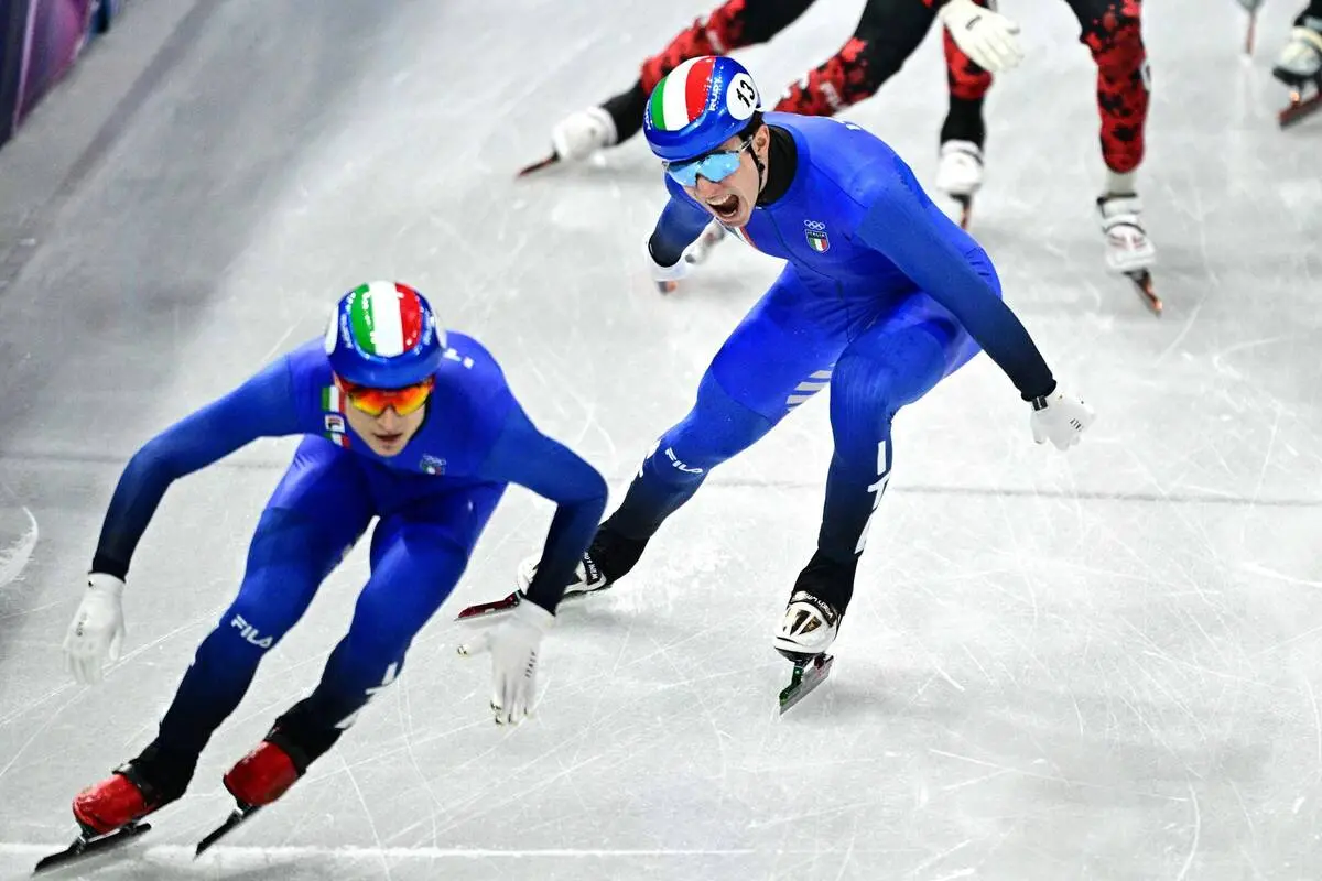 Team Italy's Pietro Sighel and Thomas Nadalini compete to win gold in the short track speed skating mixed team relay final during the Milano Cortina 2026 Winter Olympic Games at Milano Ice Skating Arena in Milan on February 10, 2026. (Photo by JULIEN DE ROSA / AFP)