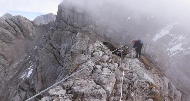 Mamma e papà col bimbo in braccio senza protezioni sulla ferrata