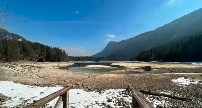 In secca il lago di Tovel: escursionisti camminano sui fondali asciugati dalla siccità