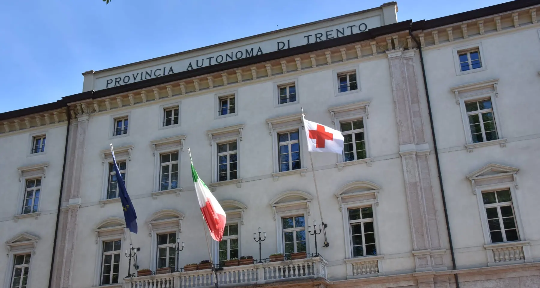 La bandiera della Croce Rossa sul palazzo della Provincia e in 22 Comuni trentini